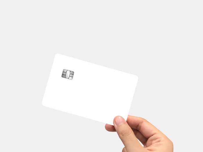 Close-up of hand holding paper against white background