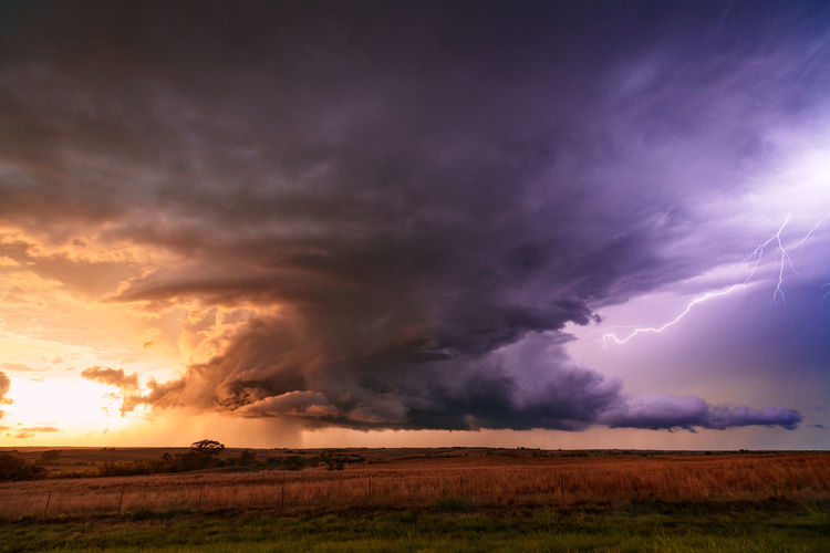 Dramatic light illuminates a supercell thunderstorm at sunset near strong city, oklahoma.
