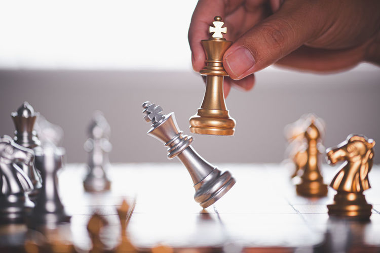 Close-up of hand holding chess pieces