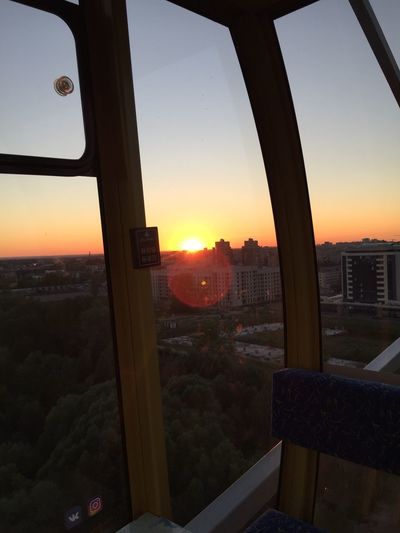 Cityscape seen through window during sunset
