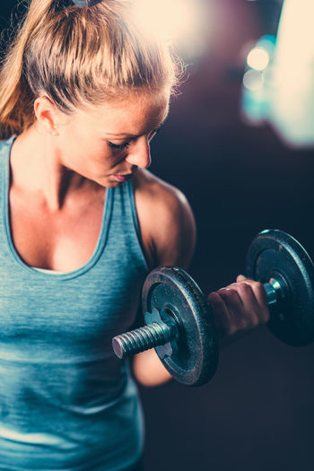 Close-up of mid adult woman lifting dumbbell