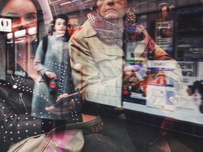 Digital composite image of people photographing through glass window