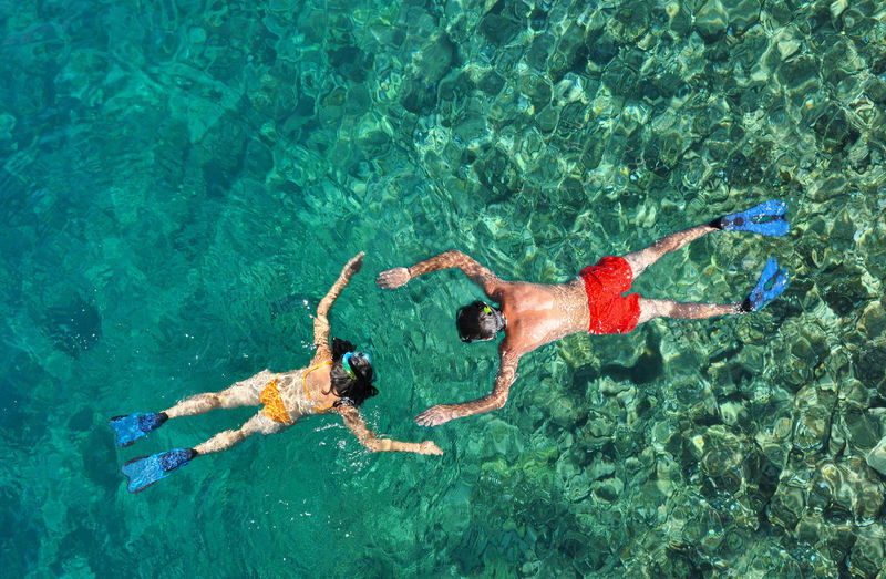 High angle view of men and woman swimming in sea