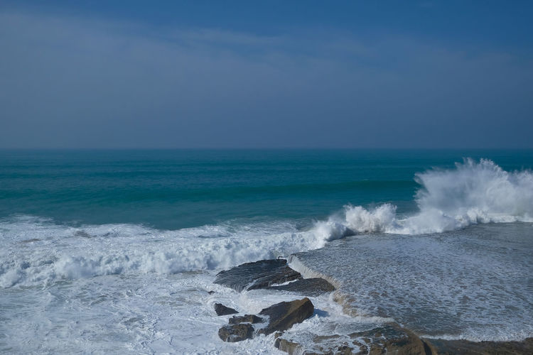 Scenic view of sea and waves against sky