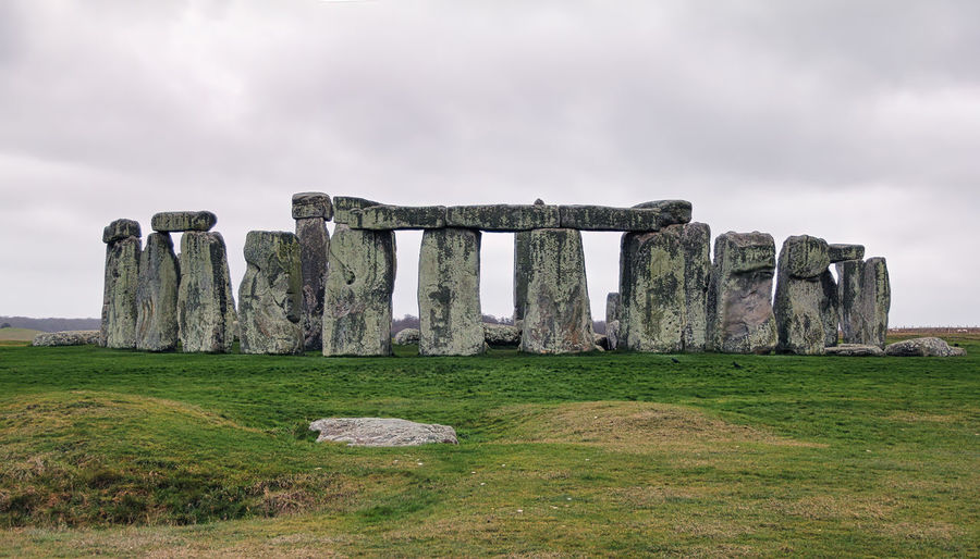 Built structure on field against cloudy sky