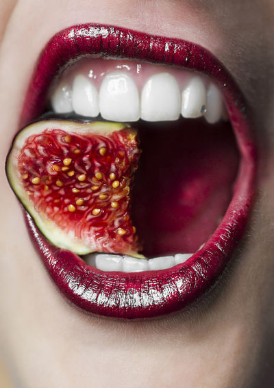 Midsection of woman eating fig