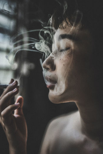 Close-up portrait of man smoking cigarette