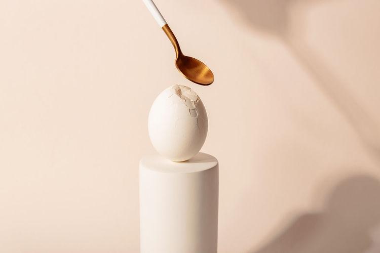 One white easter egg on a podium against a neutral background. minimalism and simplicity aesthetics
