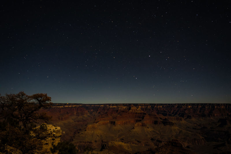 Scenic view of landscape against star field at night