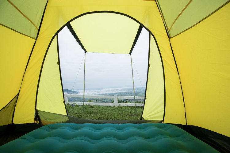 Close-up of tent on field seen through glass window