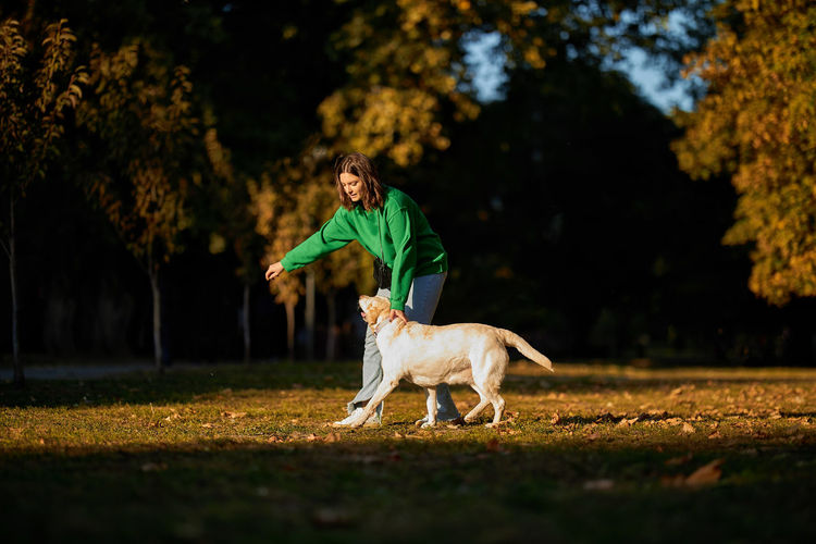 Portrait of woman with dog running on field
