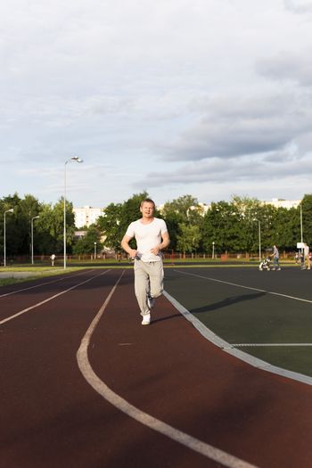Full length of man running on sports track
