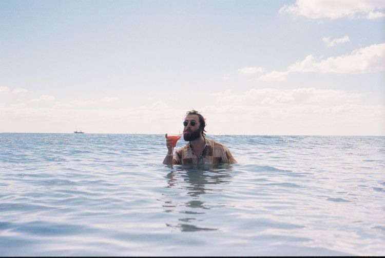 Man drinking cocktail in sea