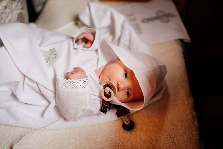 High angle view of cute baby lying on bed at home