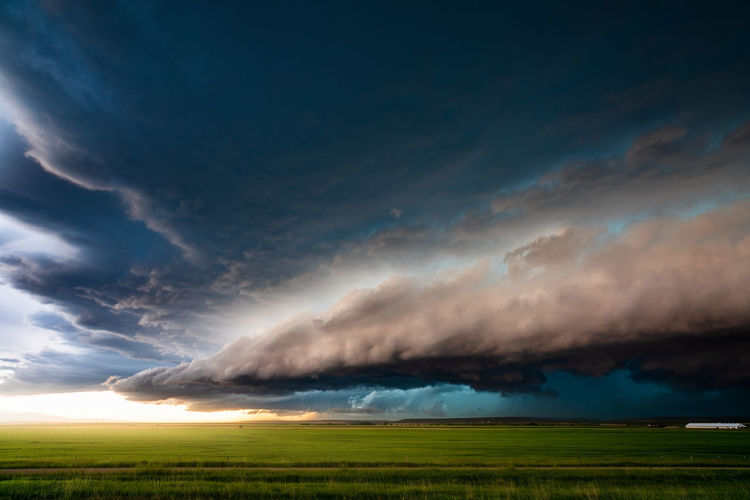 Sunlight illuminates dramatic storm clouds ahead of a thunderstorm near lewistown, montana. 