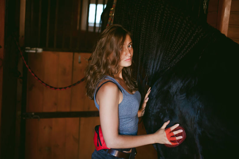 Woman with horse in stable