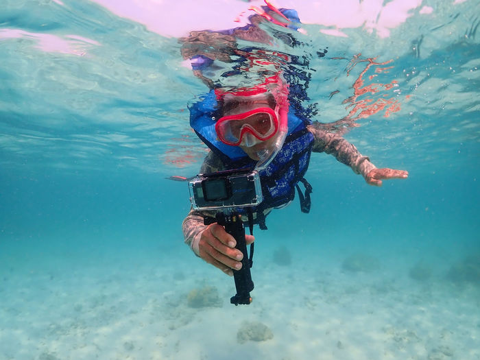 Man filming while swimming in sea