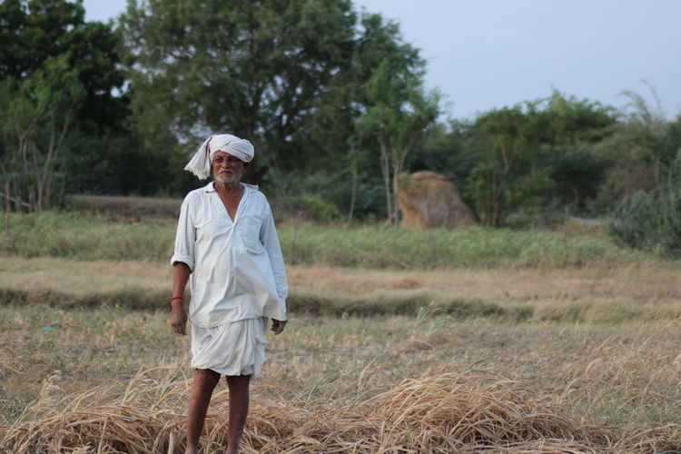 Farmer standing on field at farm