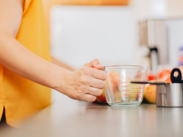 Woman holding measuring cup in kitchen