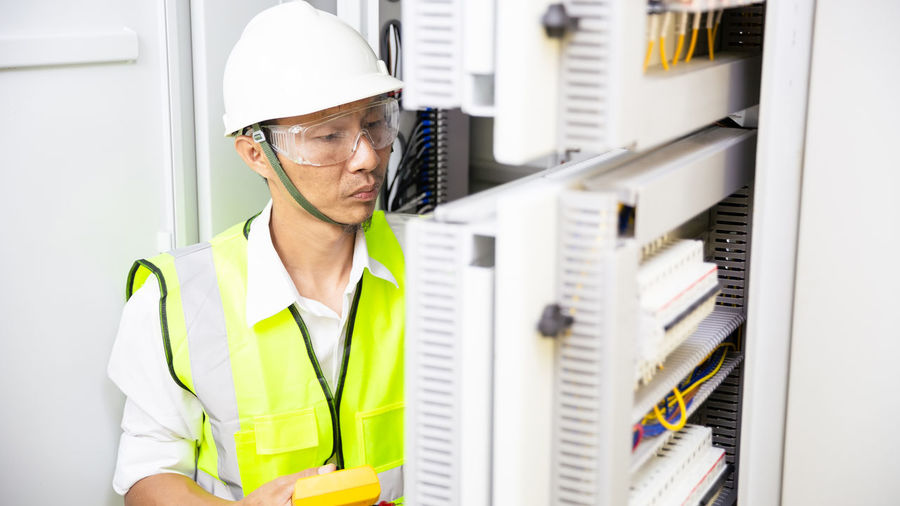 Electrician engineer work tester measuring voltage of power electric line