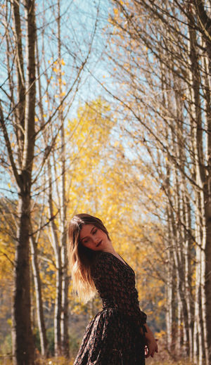 Portrait of young woman in autumn tree