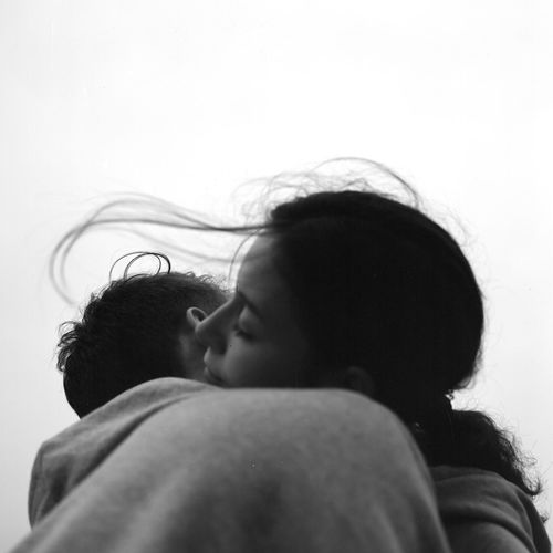 Close-up of couple embracing against sky