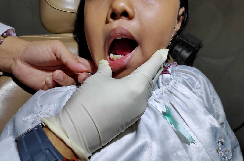 Close-up of dentist examining girl teeth