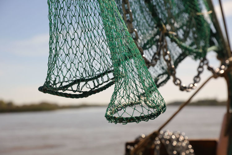 Close-up of fishing net against blue sky