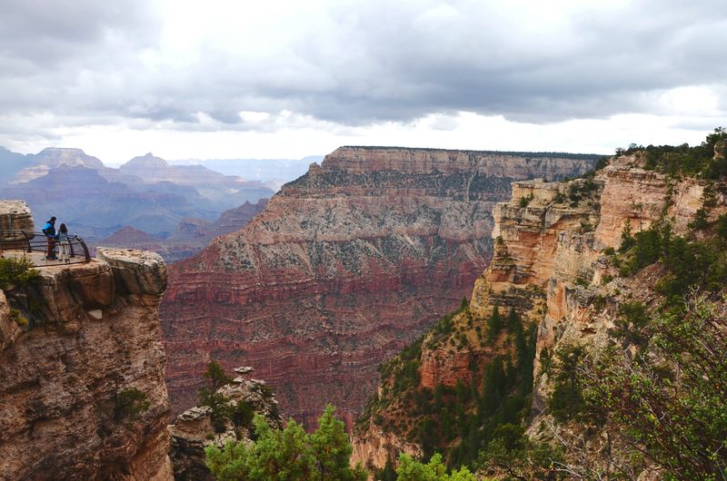 Scenic view of valley and mountains against cloudy sky at grand canyon