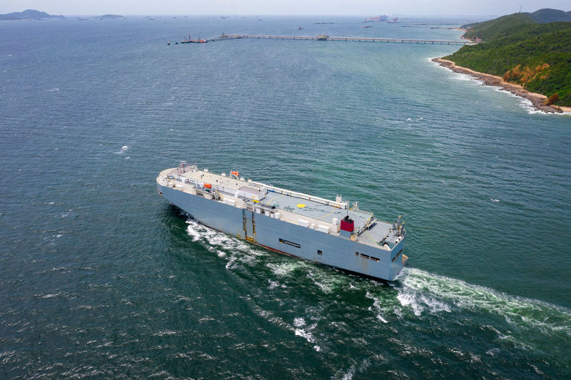 Aerial view of large roro vehicle carrier vessel sailing on the green sea