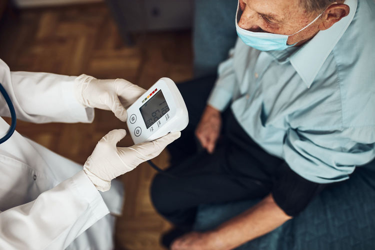 Doctor carying out blood pressure test and heart rate of senior man. checking health condition