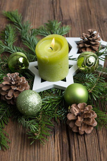 Close-up of lit candle on wreath