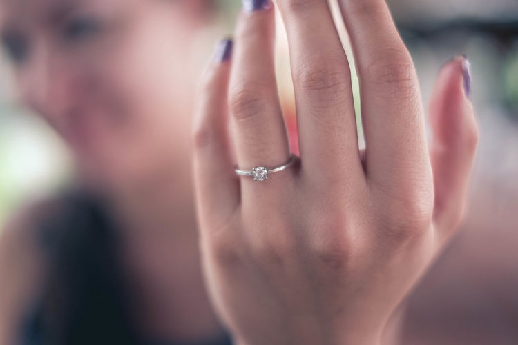 Close-up of woman showing engagement ring