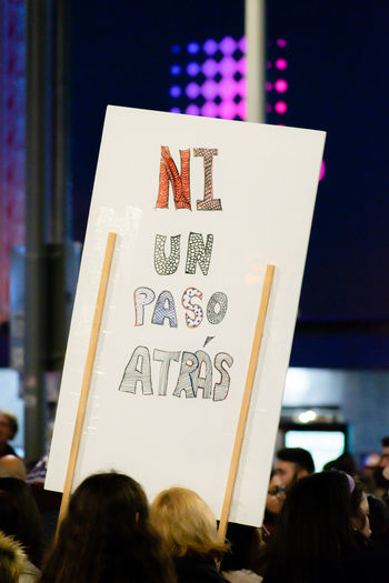People holding placards with text during protest at night