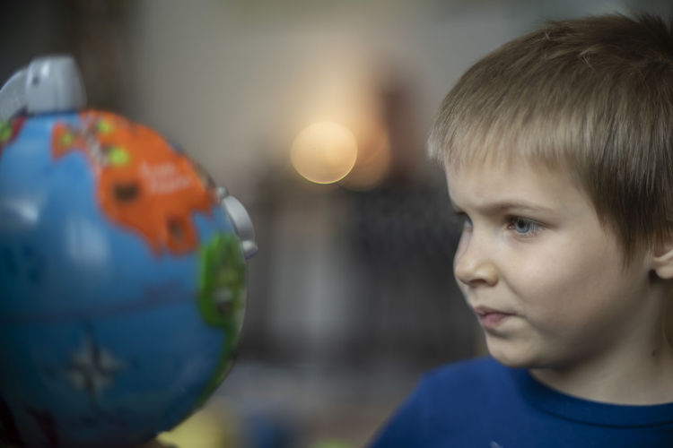 Close-up of boy looking at globe