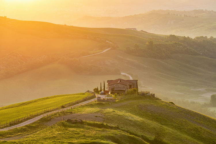 Country house on a hill in the valley at sunrise