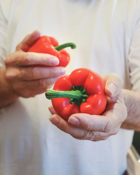 Midsection of man holding sweet pepper