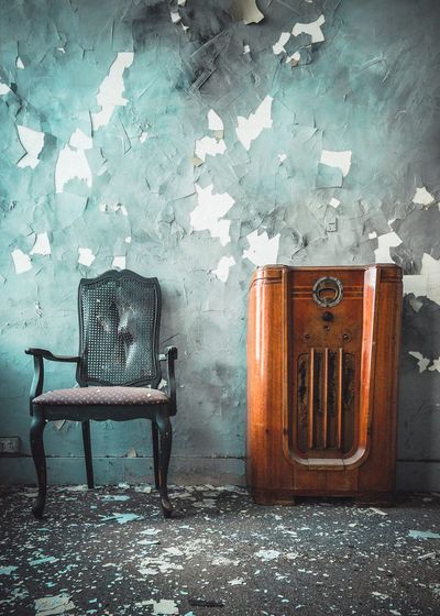 Empty chairs against wall in abandoned room