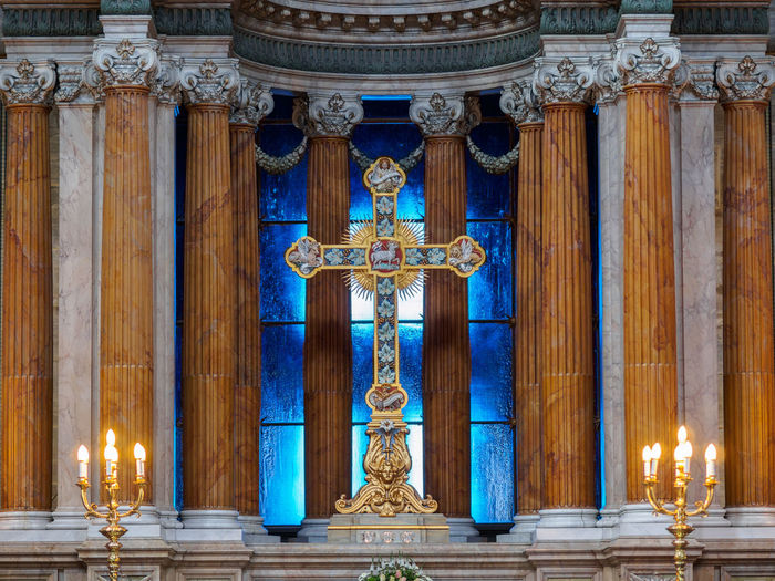 Cross amidst lit candlestick holder at church