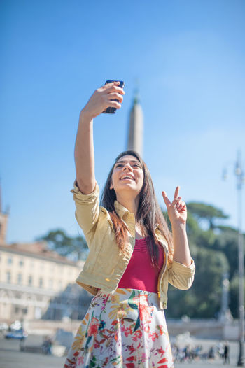 Women taking selfie against clear blue sky