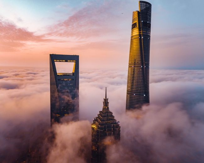 Skyscrapers amidst cloudscape during sunset