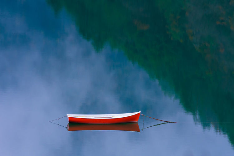 Red boat moored on lake