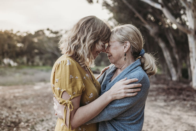 Lifestyle portrait of adult mother and senior mother embracing
