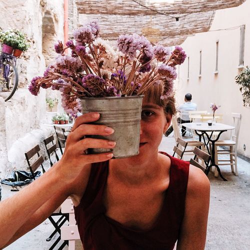 Portrait of woman holding flower pot in cafe