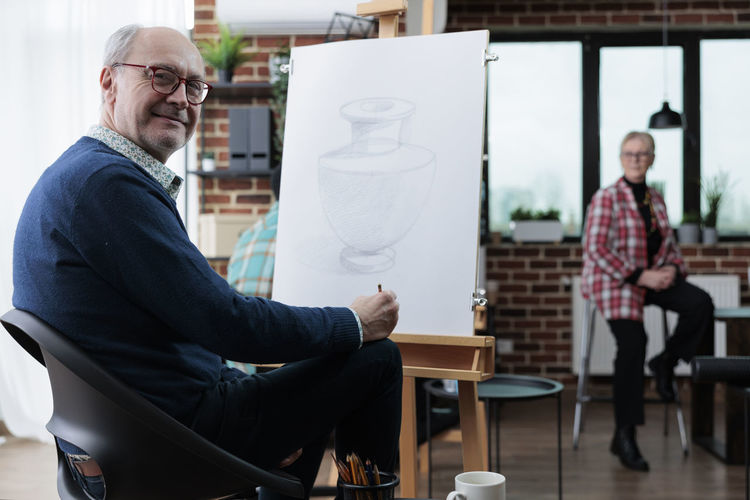 Portrait of smiling man with drawing at workshop