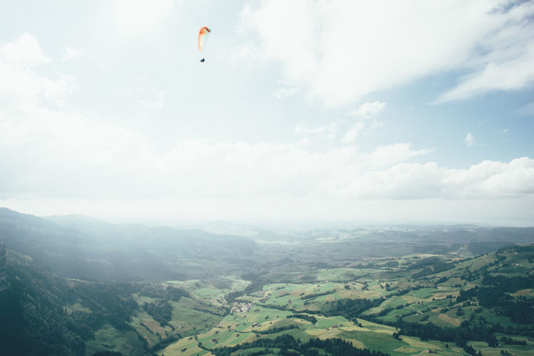 Low angle view of parachute over landscape in foggy weather
