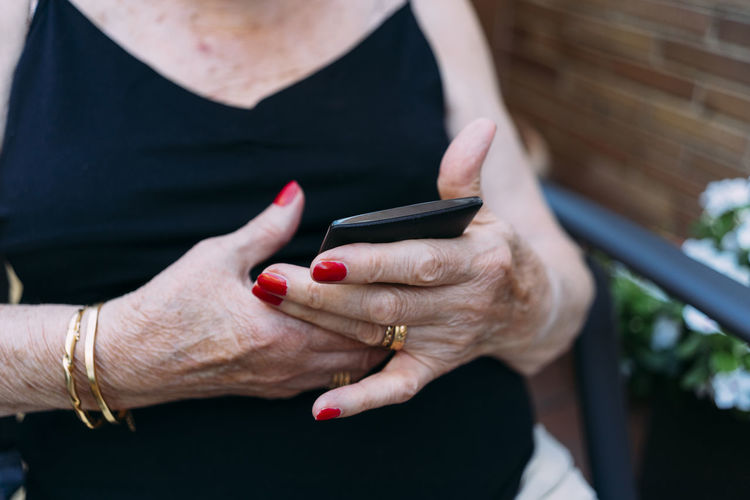 Hands of senior woman using smartphone