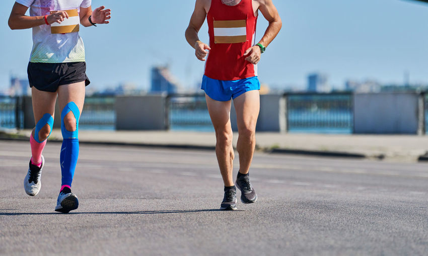Running men. sportsmen jogging in sportswear on city road. healthy lifestyle, fitness hobby