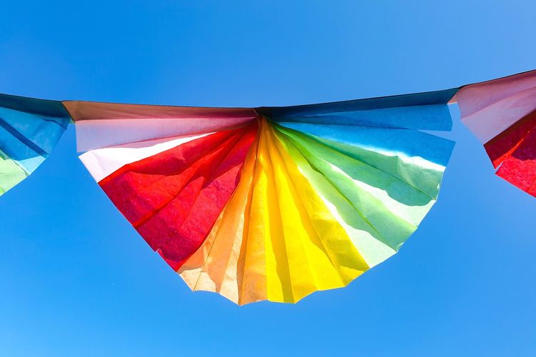Low angle view of flag against clear blue sky