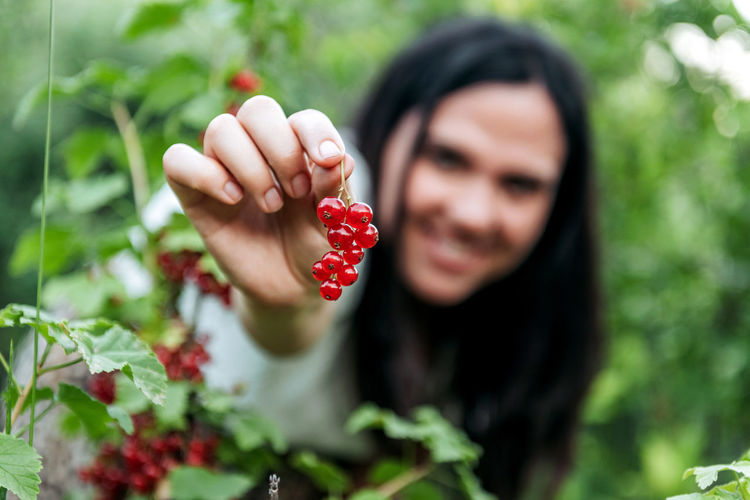 Woman holding berry at farm